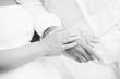 monotone shot of couple holding hands wear rings on sand