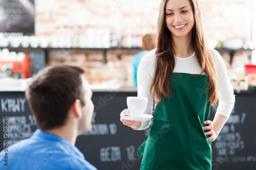 Photo: Waitress serving man coffee Waitress serving man coffee
