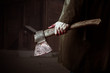 Foto: Axe with blood in male hand Axe with blood in male hand
