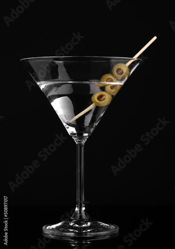 Photo: Martini glass and olives isolated on black Martini glass and olives isolated on black