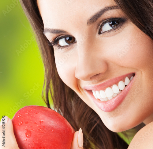 Photo: Young woman with red apple, outdoors Young woman with red apple, outdoors