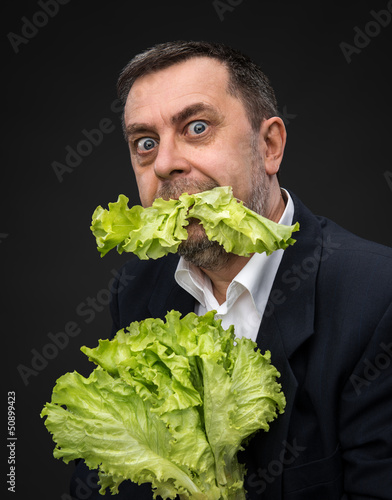 Photo: Man holding and eating lettuce Man holding and eating lettuce