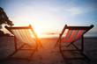 Loungers on the deserted coast sea at sunrise.