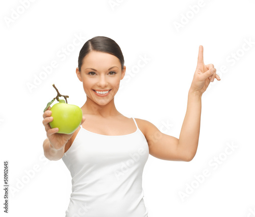 Photo: woman with green apple pointing her finger up woman with green apple pointing her finger up