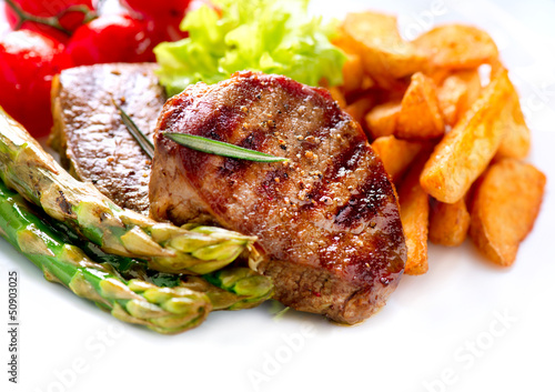 Photo: Grilled Beef Steak Meat with Fried Potato, Asparagus, Tomatoes Grilled Beef Steak Meat with Fried Potato, Asparagus, Tomatoes