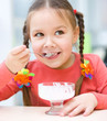Little girl is eating ice-cream in parlor