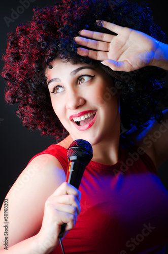 Photo: Female performer at disco with mic Female performer at disco with mic
