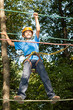Young boy with equipment climber moves on ropes.