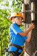 young man with climber equipment intently keeps rope