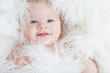 Photo: Portrait of a smiling baby wrapped in a white fur. Portrait of a smiling baby wrapped in a white fur.