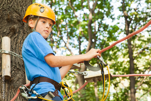 Photo: Young guy with climber equipment focused for moving. Young guy with climber equipment focused for moving.