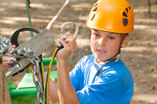 Photo: Young guy with equipment climber engages the anchor. Young guy with equipment climber engages the anchor.