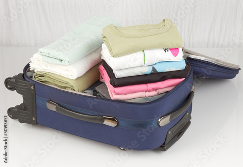 Photo: An opened suitcase packed with a lot of colorful cloths An opened suitcase packed with a lot of colorful cloths
