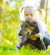 Happy child playing with dog in green field