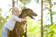 little girl in the park with a dog