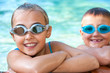 Kids in swimming pool with goggles.