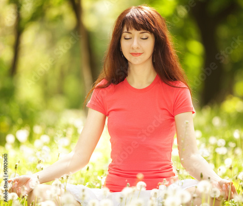Photo: Pretty woman meditate in the park Pretty woman meditate in the park