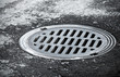 Sewer manhole on the urban asphalt road. Closeup photo