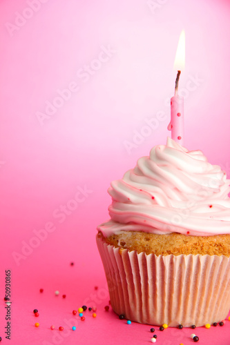 Photo: tasty birthday cupcake with candle, on pink background tasty birthday cupcake with candle, on pink background