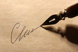 Closeup of signature (fake, not real) and ink pen, on old paper