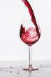 Ein Glas Rotwein eingiessen