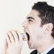 Geschaeftsmann isst Tabletten
