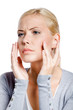 Woman examining her face and wrinkles that can appear