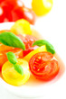 Assorted colorful red and yellow cherry tomatoes in plate on whi