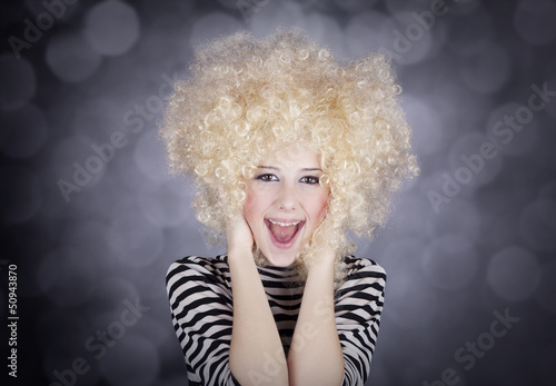 Photo: Portrait of funny girl in blonde wig. Studio shot. Portrait of funny girl in blonde wig. Studio shot.