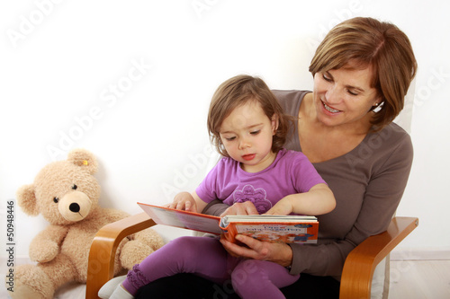Photo: Eine Oma liest ihrer Enkeltochter aus einem Buch vor. Eine Oma liest ihrer Enkeltochter aus einem Buch vor.