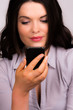 Beautiful young female reading iphone device
