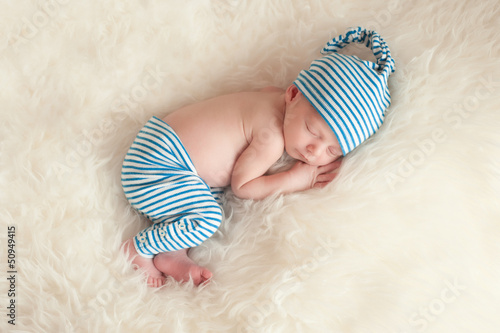 Photo: Sleeping Newborn Baby Wearing Pajamas and a Sleeping Cap Sleeping Newborn Baby Wearing Pajamas and a Sleeping Cap