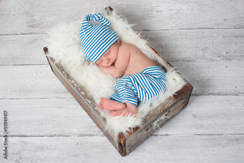 Photo: Sleeping Newborn Baby Wearing Pajamas and a Sleeping Cap Sleeping Newborn Baby Wearing Pajamas and a Sleeping Cap
