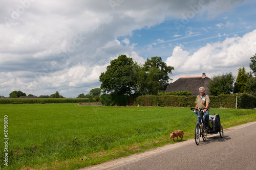 Photo: Elderly man at the bike with dog Elderly man at the bike with dog