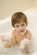Cute boy taking a bath with foam