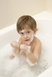 Cute boy taking a bath with foam