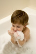 Cute boy taking a bath with foam