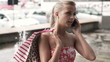 Woman with shopbags talking on cellphone in the city