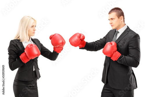 Photo: Young businesspeople with boxing gloves having a fight Young businesspeople with boxing gloves having a fight