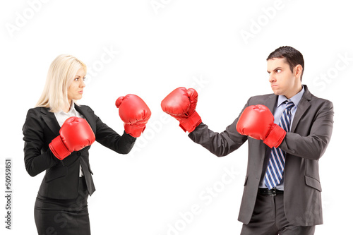 Photo: Young businesspeople with boxing gloves having a fight Young businesspeople with boxing gloves having a fight