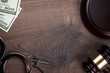 handcuffs gavel and money on wooden background