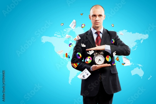 Photo: Business man holding alarmclock Business man holding alarmclock