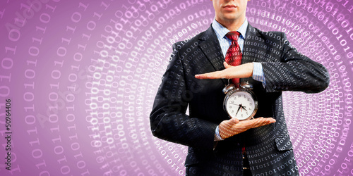 Photo: Business man holding alarmclock Business man holding alarmclock