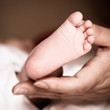 newborn baby feet on female hand