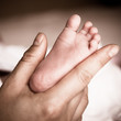 newborn baby feet on female hand