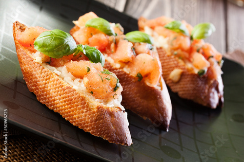 Photo: Bruschetta with mozzarella and tomato. Selective focus Bruschetta with mozzarella and tomato. Selective focus