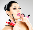 Woman with makeup cosmetic tools near her face.