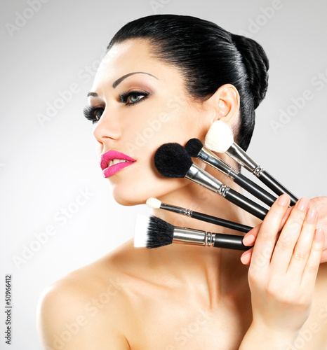Photo: Beautiful woman with makeup brushes Beautiful woman with makeup brushes