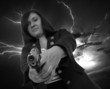 woman with handgun and dark sky