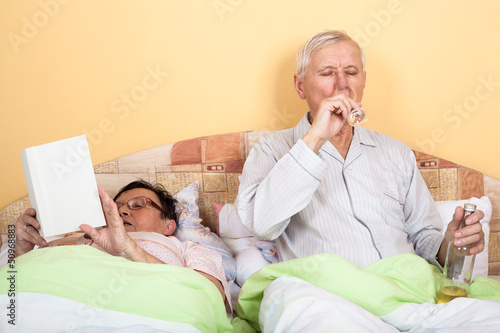 Photo: Seniors relax with alcohol in bed Seniors relax with alcohol in bed